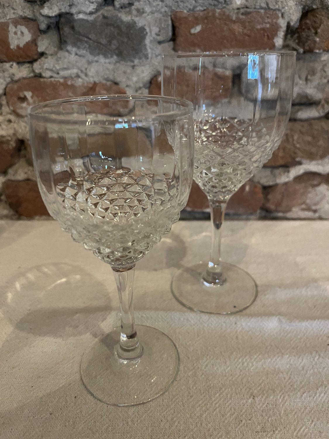 Twee wijnglazen op voet met een geslepen diamantmotief, een groot en een kleiner